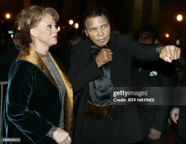 Boxing legend Muhammad Ali strikes a boxing pose on the red carpet with his wife Lonnie, 19 November 2005, before the Grand Opening Gala for the...