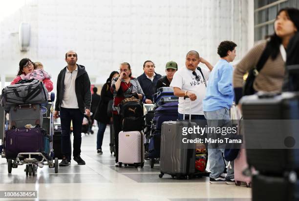 Travelers gather with their luggage in the international terminal at Los Angeles International Airport ahead of the Thanksgiving holiday on November...