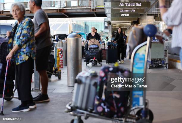 Travelers gather outside the international terminal at Los Angeles International Airport ahead of the Thanksgiving holiday on November 22, 2023 in...