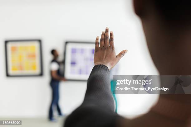 female black gallery owner hanging a picture - gallery 2 stock pictures, royalty-free photos & images