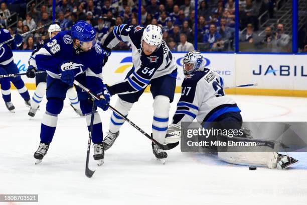 Connor Hellebuyck of the Winnipeg Jets stops a shot from Brandon Hagel of the Tampa Bay Lightning during a game at Amalie Arena on November 22, 2023...