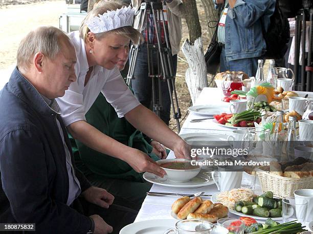 Russian President Vladimir Putin attends a dinner with farmers at a corn field September 17, 2013 near Ust Labinsk, Krasnodar region, Russia. Putin...