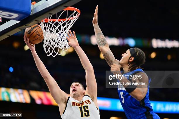 Nikola Jokic of the Denver Nuggets shoots the ball against Paolo Banchero of the Orlando Magic in the first half of a game at Amway Center on...