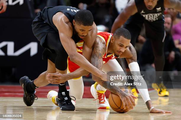 Mikal Bridges of the Brooklyn Nets and Dejounte Murray of the Atlanta Hawks battle for the ball during the second half at State Farm Arena on...