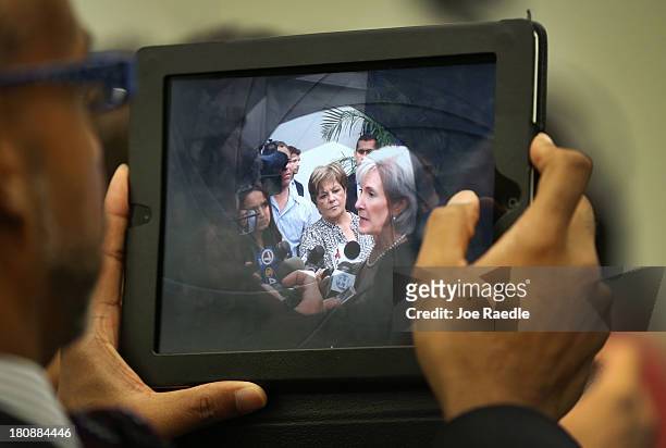Health and Human Services Secretary Kathleen Sebelius is seen on a tablet device as she speaks with the media after participating in a conference to...