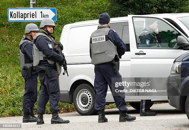 Armed police officiers block a road near Grosspriel, some 65 kilometers west of Vienna, on September 17, 2013 where a man hideS himself with a police...