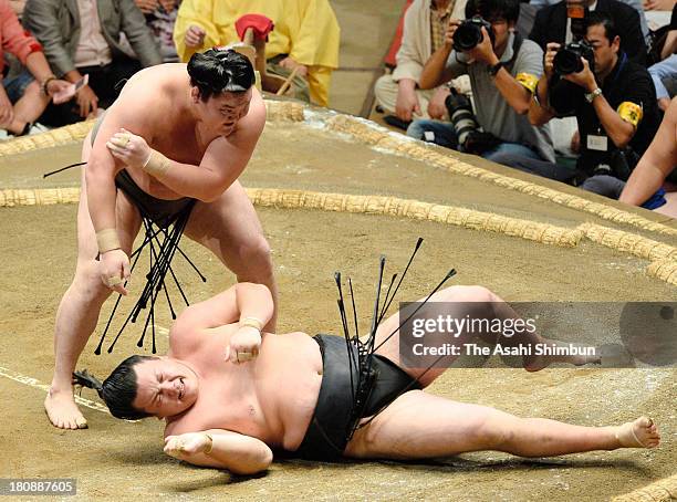 Mongolian yokozuna Hakuho , whose real name is Mnkhbatyn Davaajargal throws Ikioi during day two of the Grand Sumo Autumn Tournament at Ryogoku...