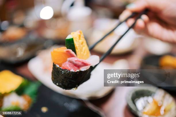 freunde essen in einem japanischen restaurant luxuriöse japanische küche mit verschiedenen sushi, meeresfrüchten, austern, sashimi frisch auf dem esstisch in einem restaurant serviert. - sushi stock-fotos und bilder
