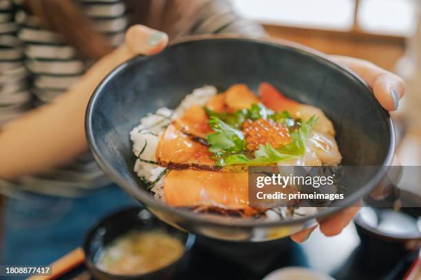 group of people eating salmon and tuna set with miso soup donburi rice bowl in japan - ikura stock pictures, royalty-free photos & images