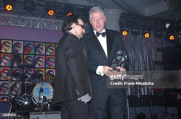 President Bill Clinton presents musician Bono with the Person of the Year award during the13th Annual MusiCares Person Of The Year tribute at the...