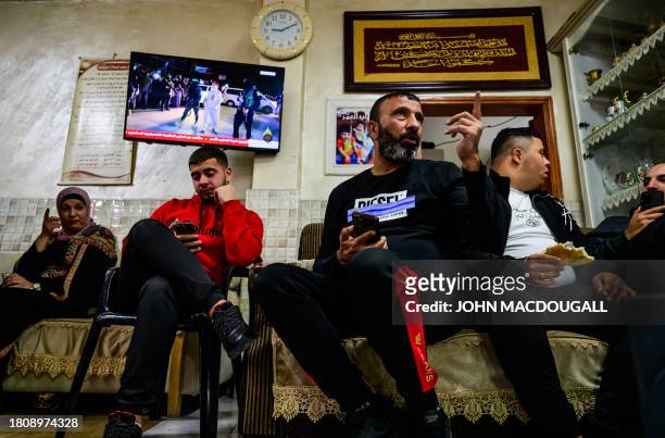 Relatives of Ahmad Salaima, a 14-year-old Palestinian about to be released under an extended truce deal, sit in wait as a TV broadcasts live coverage...