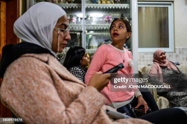 Young relative of Ahmad Salaima, a 14-year-old Palestinian about to be released under an extended truce deal, glances up at a TV broadcasting live...