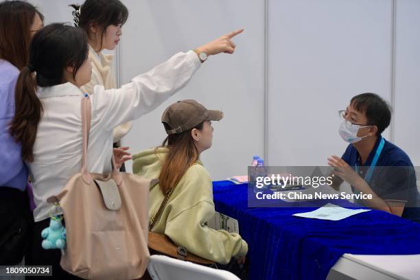 Job applicant talks with a recruitment officer at Guangdong-Hong Kong-Macao Greater Bay Area job fair on November 22, 2023 in Shenzhen, Guangdong...