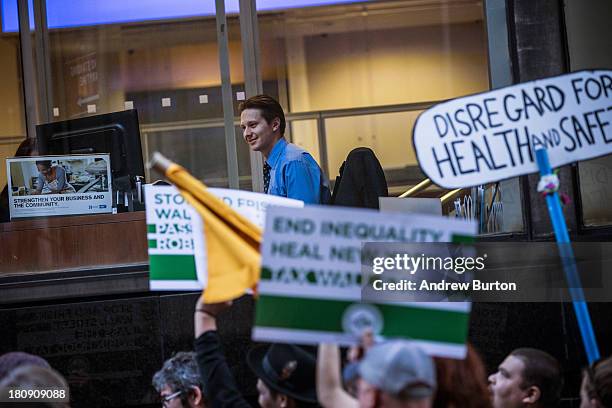 Occupy Wall Street protesters walk past a man working inside a Chase Bank during a march from the United Nations building to Bryant Park on September...