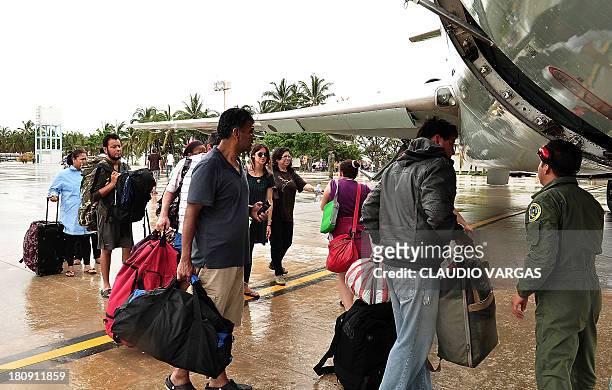 Tourists board a plane of the Mexican Air Force at the Pie de La Cuesta military base in Acapulco, state of Guerrero, Mexico, on September 17, 2013....
