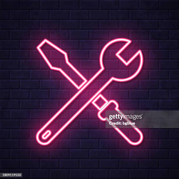 tools - wrench and screwdriver. glowing neon icon on brick wall background - building wall night stock illustrations