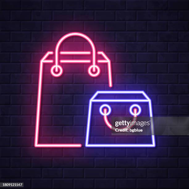 stockillustraties, clipart, cartoons en iconen met shopping bags. glowing neon icon on brick wall background - pakjesavond