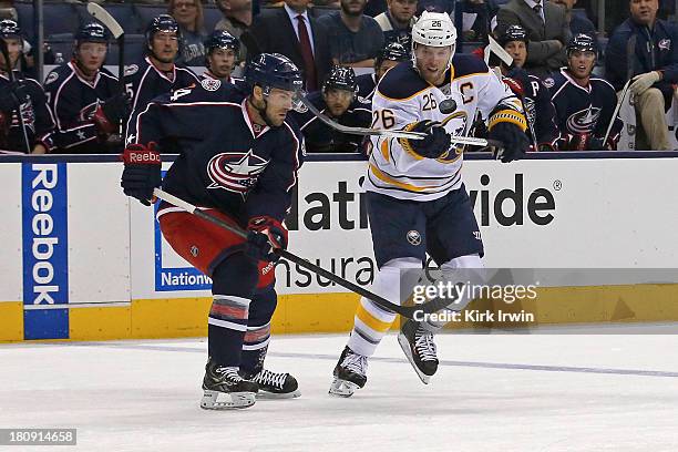 Thomas Vanek of the Buffalo Sabres bounces the puck on his stick while attempting to keep control of the puck away from Andrew Joudrey of the...