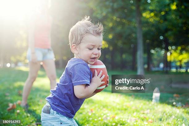 baby with rugby ball - child animated watching stock-fotos und bilder