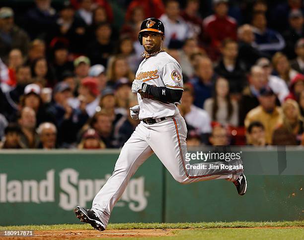 Alexi Casilla of the Baltimore Orioles, pinch running for Danny Valencia, scores the winning run on a sacrifice fly, which was hit on a pitch thrown...