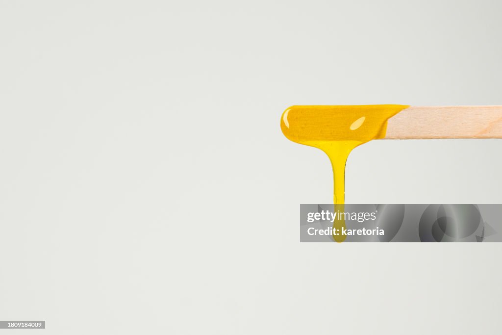 Liquid sugar wax on wooden spatula