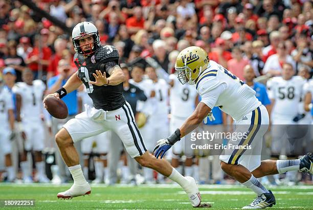 Quarterback Taylor Martinez of the Nebraska Cornhuskers runs past linebacker Aaron Wallace of the UCLA Bruins during their game at Memorial Stadium...