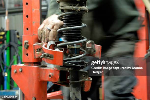 technician repairs automobile shock absorbers - shock absorber stock pictures, royalty-free photos & images