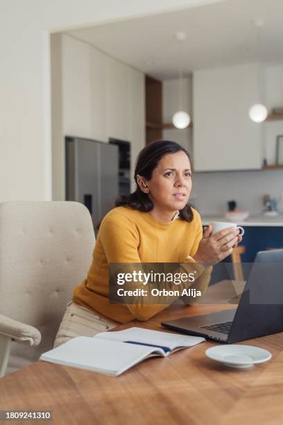 hearing impaired woman using laptop at home - tone deaf stock pictures, royalty-free photos & images
