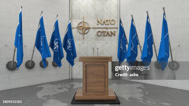 nato otan concept with nato flag in a row with a empty wooden wall. press conference in government building - nato flag imagens e fotografias de stock