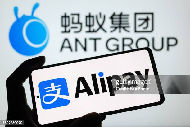 The Alipay logo is being displayed on a smartphone with the Ant Group in the background, in this photo illustration in Brussels, Belgium, on November...
