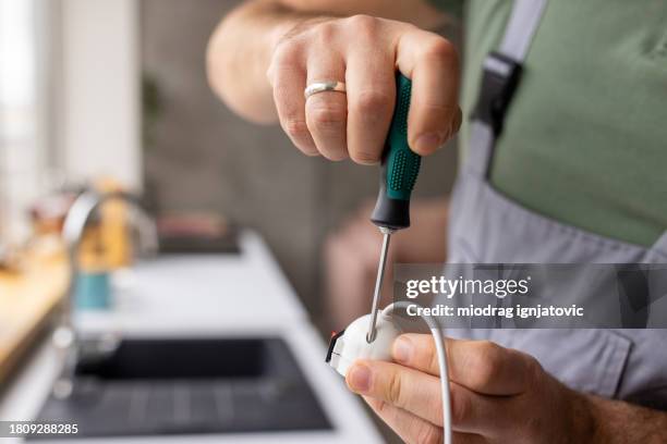 electrician repairing a light bulb socket in an apartment - handyman overalls stock pictures, royalty-free photos & images