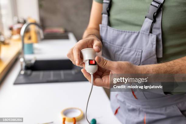 electrician repairing a light bulb socket in an apartment - handyman overalls stock pictures, royalty-free photos & images