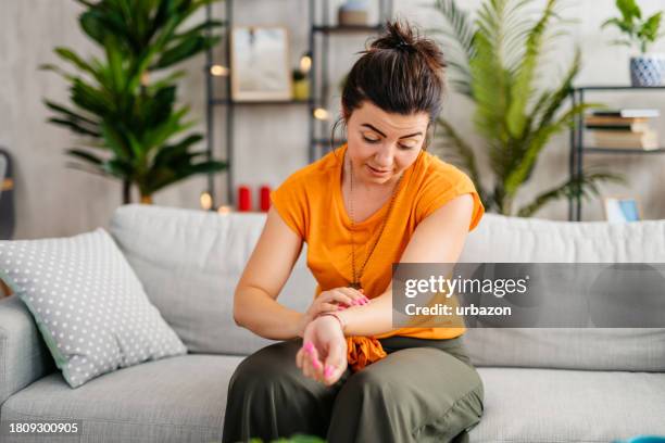 young woman scratching her skin at home - skin rash stock pictures, royalty-free photos & images