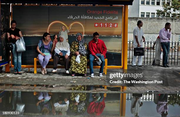 Locals wait for the local bus in the Tunisian capital on September 4, 2013. After the so called Arab Spring, which began in Tunis when a vegetable...