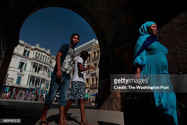 Locals walk past the gate to the Medina in Tunis. This World Heritage site was erected in the 7th century and has been the focal point of the city...