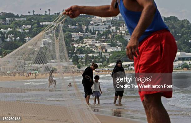 Locals enjoy a day on the beach off the coast of Tunis on September 4, 2013.