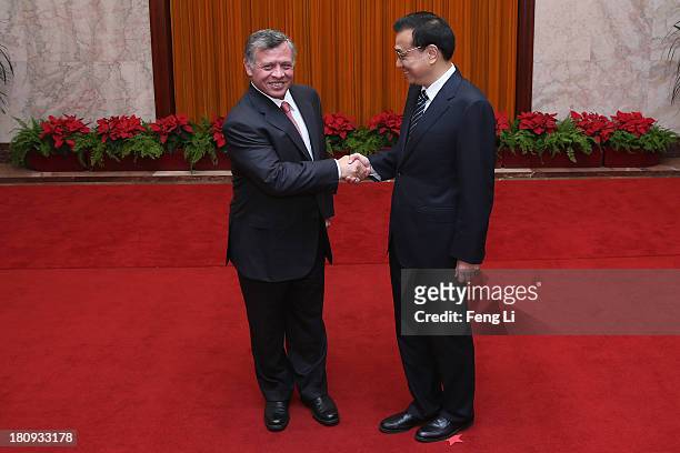 King Abdullah II bin Al Hussein of Jordan shankes hands with Chinese Premier Li Keqiang at the Great Hall of the People on September 18, 2013 in...