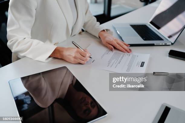 businesswoman signing an official document - legal assistance stock pictures, royalty-free photos & images