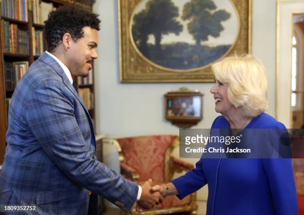 Queen Camilla shakes hands with author Jonathan Escoffery, who is nominated for "If I Survive You" during the Booker Prize Foundation reception at...