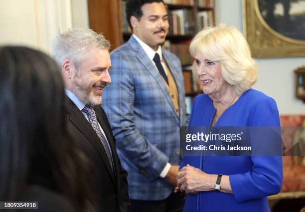 Queen Camilla smiles as she speaks with author Paul Harding, who is nominated for "The Other Eden" during the Booker Prize Foundation reception at...
