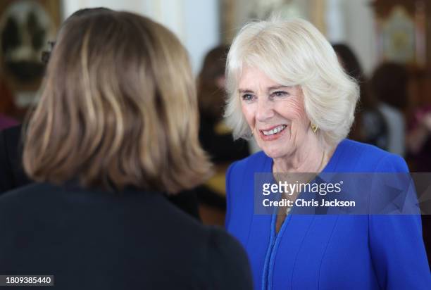 Queen Camilla smiles as she speaks to a guest during the Booker Prize Foundation reception at Clarence House on November 23, 2023 in London, England.