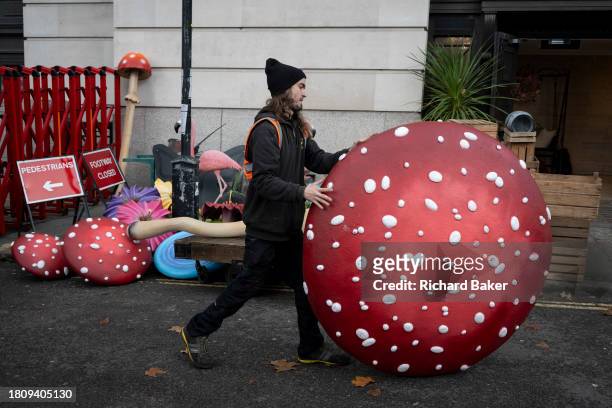 Work crew organises delivers fibreglass props including toadstools, flowers and flamingos into a venue for a forthcoming event promoting the new...
