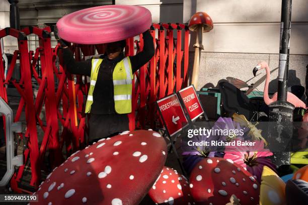 Work crew organises and carries fibreglass props including toadstools, flowers and flamingos into a venue for a forthcoming event promoting the new...