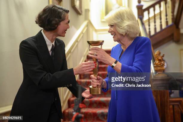 Queen Camilla is asked to hold the trophy until its presented by Gaby Wood, Director of the Booker Prize Foundation during the Booker Prize...
