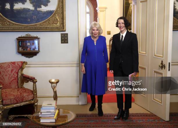 Queen Camilla smiles as she arrives with Gaby Wood, Director of the Booker Prize Foundation to host a reception at Clarence House on November 23,...
