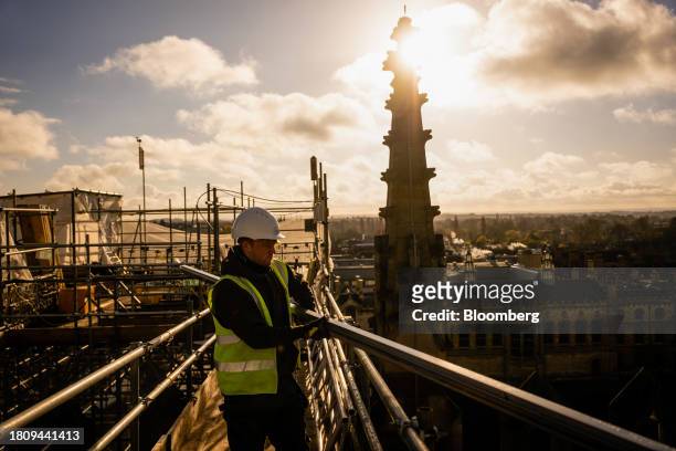 Construction worker prepares the roof for the installation of solar panels at King's College Chapel at Cambridge University in Cambridge, UK, on...