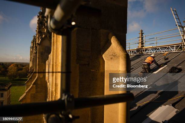 Construction worker prepares the roof for the installation of solar panels at King's College Chapel at Cambridge University in Cambridge, UK, on...