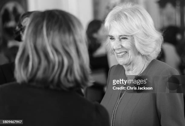 Queen Camilla smiles as she speaks to a guest during the Booker Prize Foundation reception at Clarence House on November 23, 2023 in London, England.