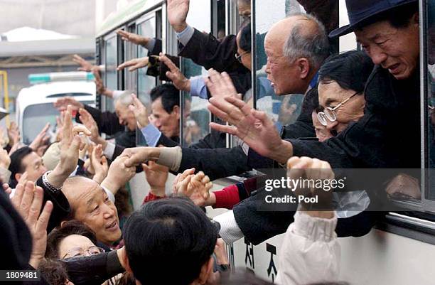 South Koreans wave to their North Korean relatives from their bus as they bid farewell at the Mount Kumgang resort February 22, 2003 in North Korea....
