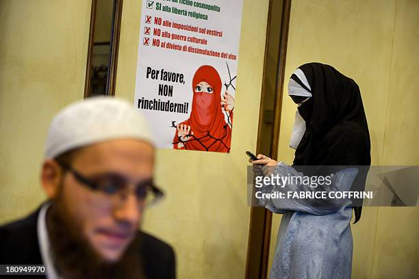 Islamic Central Council of Switzerland member Nora Illi , one of the few Swiss women wearing the niqab, checks her mobile phone on September 18, 2013...